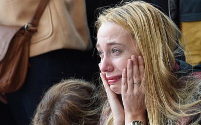 A woman reacts at a makeshift memorial near the Bataclan concert hall in Paris on November 15, 2015, two days after a series of deadly attacks. (AFP PHOTO / MIGUEL MEDINA)