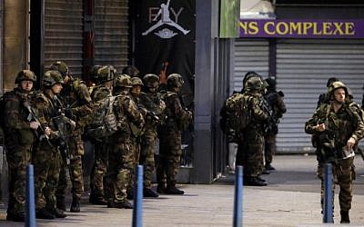 French army soldiers stand in position in the northern Paris suburb of Saint-Denis, on November 18, 2015, as French Police special forces raid an apartment, hunting those behind the attacks that claimed 130 lives in the French capital five days ago. (AFP PHOTO/KENZO TRIBOUILLARD)