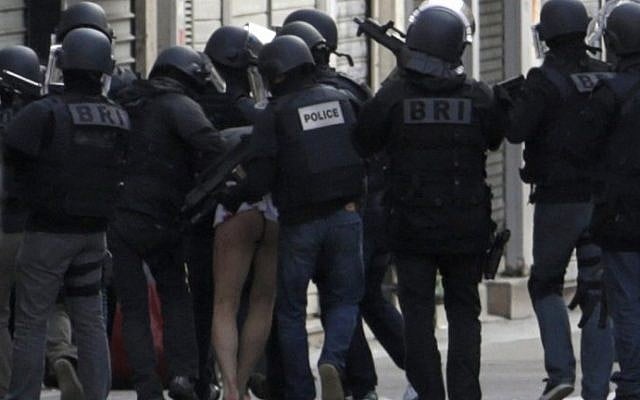 A man is evacuated after being arrested by French policemen in the northern Paris suburb of Saint-Denis city center, on November 18, 2015, as French Police special forces raid an apartment, hunting those behind the attacks that claimed 129 lives in the French capital five days ago. (AFP PHOTO / KENZO TRIBOUILLARD) A man is evacuated after being arrested by French policemen in the northern Paris suburb of Saint-Denis city center, on November 18, 2015, as French Police special forces raid an apartment, hunting those behind the attacks that claimed 129 lives in the French capital five days ago. (AFP PHOTO / KENZO TRIBOUILLARD)