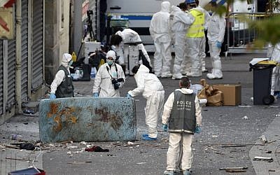 French police teams search for evidence outside a building after a raid in the northern Paris suburb of Saint-Denis, on November 18, 2015. (AFP/ERIC FEFERBERG)