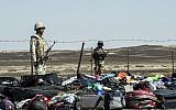 Egyptian army soldiers stand guard next to the luggage and belongings of passengers of the A321 Russian airliner piled up at the site of the crash in Wadi el-Zolmat, a mountainous area in Egypt's Sinai Peninsula on November 1, 2015. (AFP PHOTO/KHALED DESOUKI)