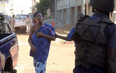 Malian security forces escort a hostage freed from the Radisson Blu hotel in Bamako on November 20, 2015, after gunmen went on a shooting rampage. (AFP PHOTO/HABIBOU KOUYATE)