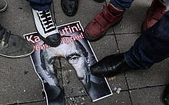 Turkish protesters walk over a burnt poster depicting Russian President Vladimir Putin and reading 'Putin, killer!' during an anti-Russia demonstration in Istanbul, November 27, 2015. (AFP/Cagdas Erdogan)