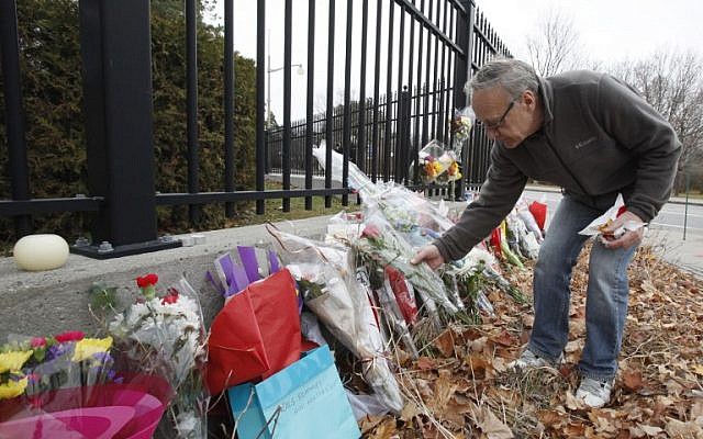 A man leaves a flower at the French Embassy in Ottawa on November 14, 2015, one day after the terrorist attacks in Paris. (AFP PHOTO / Patrick Doyle)