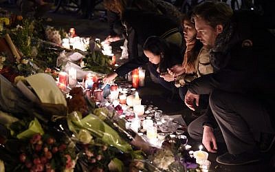 People pay tribute to the victims of the November 13 terrorist attacks in Paris, at Charron street in Paris, on November 14, 2015. (Photo by AFP Photo / Eric Feferberg)