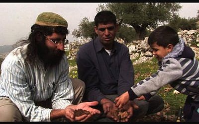 Muhammad Ziad Sabateen, right, as a young child plays with his father Ziad Sabateen, center, and Jewish peace activist Shaul Judelman from the 'Shorashim -- Judur -- Roots' organization. (Courtesy) Muhammad Ziad Sabateen, right, as a young child plays with his father Ziad Sabateen, center, and Jewish peace activist Shaul Judelman from the 'Shorashim -- Judur -- Roots' organization. (Courtesy)