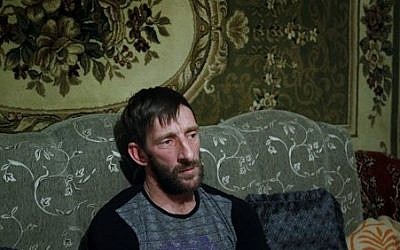 In this photo taken Thursday, Nov. 12, 2015, Abdulla Magomedov, brother of Rashid Magomedov who left to become an Islamic State fighter and was killed in Syria, sits at home in the village of Komsomolskoye, Dagestan, Russia. (Sergei Grits/AP)