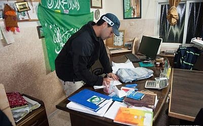 An Israeli police officer participates in a raid on offices of the Islamic Movement's northern branch overnight Monday, November 16, 2015 (Israel Police)