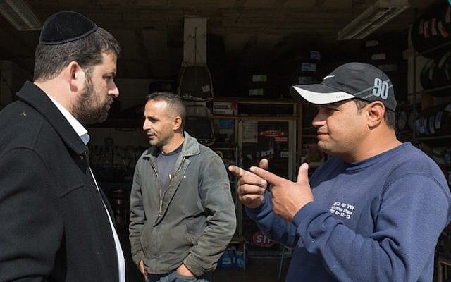 An ultra-Orthodox Jewish man from the Israeli settlement of Beitar Illit seen talking with Arabs as he gets his car washed at the Hussan Junction Palestinian-owned car wash in the West Bank, on November 11, 2015. (Nati Shohat/Flash90) An ultra-Orthodox Jewish man from the Israeli settlement of Beitar Illit seen talking with Arabs as he gets his car washed at the Hussan Junction Palestinian-owned car wash in the West Bank, on November 11, 2015. (Nati Shohat/Flash90)