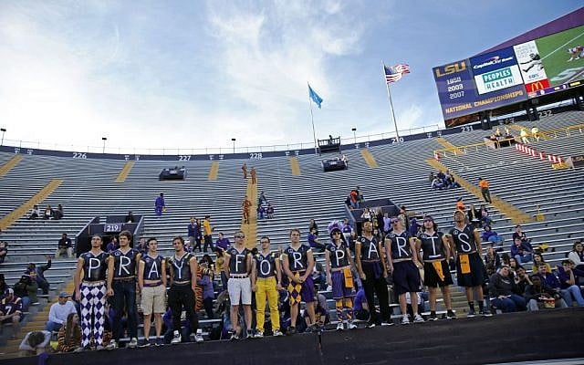 LSU students pose in Tiger Stadium with a message of prayer for the victims of yesterday's terrorist attacks in Paris, before an NCAA college football game against Arkansas in Baton Rouge, La., Saturday, Nov. 14, 2015. (AP Photo/Gerald Herbert)