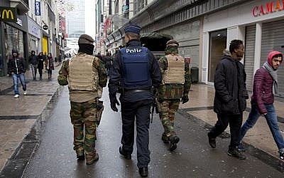 Belgian soldiers and police patrol an otherwise busy shopping street in Brussels on Saturday, November 21, 2015. (AP/Virginia Mayo)