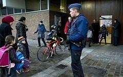 Children pass a police officer as they arrive for school in the center of Brussels on Wednesday, Nov. 25, 2015. (AP Photo/Virginia Mayo)
