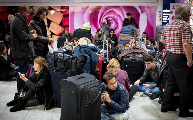 Travelers sit and wait at London's Gatwick Airport's North Terminal, Saturday Nov. 14, 2015, after the terminal was evacuated as a precaution after authorities found a suspicious article. (Stefan Rousseau/PA via AP)