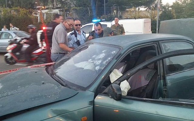 Security officers stand next to a car used in a shooting attack in the West Bank on Thursday, November 19, 2015 (Gush Etzion municipality)
