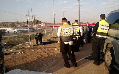 Members of the independent emergency service ZAKA wait for permission to begin cleaning blood and remains from the scene of a stabbing attack at the Gush Etzion Junction on November 22, 2015. (Judah Ari Gross/ Times of Israel)