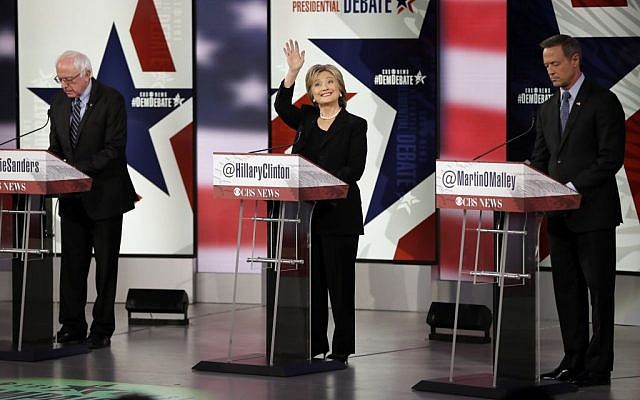 Hillary Rodham Clinton waves as Bernie Sanders, left, and Martin O'Malley prepare before a Democratic presidential primary debate, Saturday, Nov. 14, 2015, in Des Moines, Iowa. (AP Photo/Charlie Neibergall)