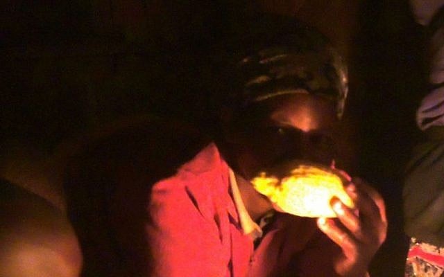 Ruth Wangechi smells an etrog donated from Israel just in time for the end of Sukkot in October, 2015. They hope to preserve the seeds to grow their own etrog tree for the future, though the climate may not be suitable. (Melanie Lidman/Times of Israel)