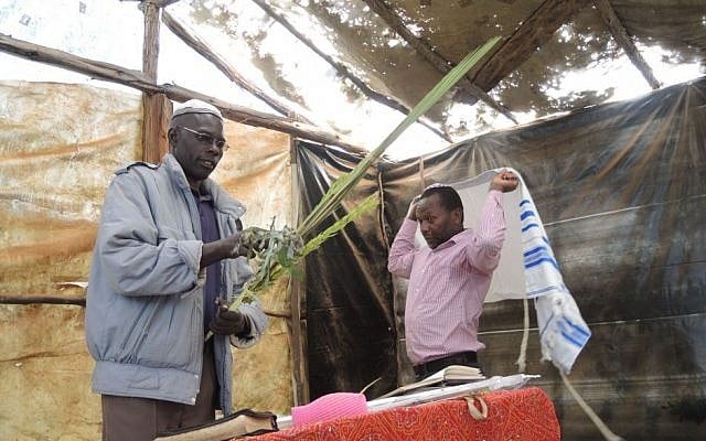 Eliyahu Wachanga and Yosef Njogu prepare to say the blessings over the lulav and etrog for the first time during Sukkot, October 2015. (Melanie Lidman/Times of Israel)