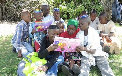 Children in the Kasuku Jewish community look at new donated books on October 4, 2015. (Melanie Lidman/Times of Israel)