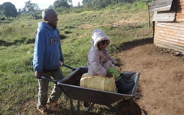 Gathundia has no running water, so the family must bring walk to bring water a few times per day. Here, two-year-old Rachel gets a free ride during a trek to bring water from a nearby stream. (Melanie Lidman/Times of Israel)