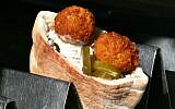 A falafel sandwich ready to be eaten, part of the pantheon of Israeli food. (Orel Cohen/Flash90)