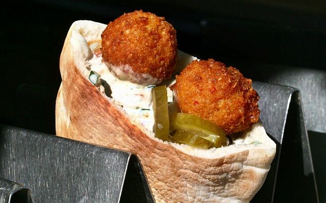 A falafel sandwich ready to be eaten, part of the pantheon of Israeli food. (Orel Cohen/Flash90)
