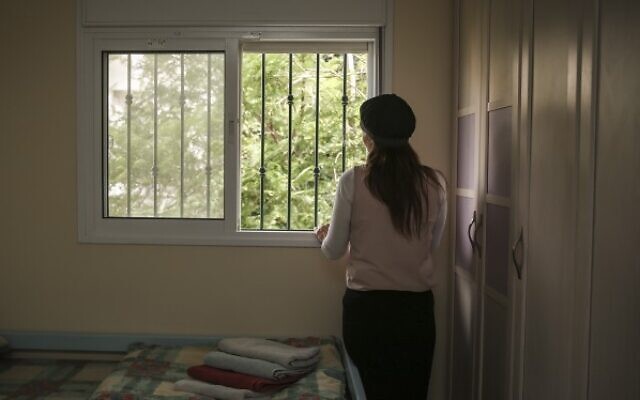 An Orthodox Jewish woman looks out the window of her room in an abused women's shelter in Beit Shemesh, July 15, 2014 (Hadas Parush/Flash90)
