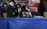 Yachad party leader Eli Yishai kisses the hand Rabbi Meir Mazuz during press conference in Bnei Brak, December 25, 2014. (Photo by Yaakov Naumi/Flash90)