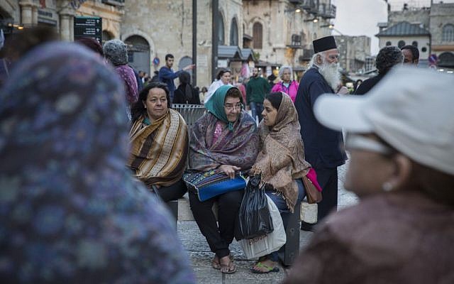 Tourists cover themselves in scarves as they wait for their group at Jaffa Gate in Jerusalem's Old City, as tempratures begin to drop and winter sets in, October 28, 2015. (Hadas Parush/Flash90) Tourists cover themselves in scarves as they wait for their group at Jaffa Gate in Jerusalem's Old City, as tempratures begin to drop and winter sets in, October 28, 2015. (Hadas Parush/Flash90)