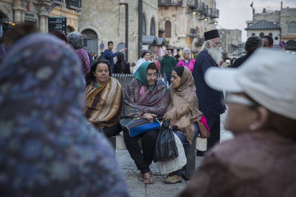 Tourists cover themselves in scarves as they wait for their group at Jaffa Gate in Jerusalem's Old City, as tempratures begin to drop and winter sets in, October 28, 2015. (Hadas Parush/Flash90) Tourists cover themselves in scarves as they wait for their group at Jaffa Gate in Jerusalem's Old City, as tempratures begin to drop and winter sets in, October 28, 2015. (Hadas Parush/Flash90)