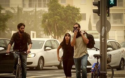 File: A man covers his face while crossing the street as a sandstorm hits Israel on November 4, 2015. (Flash90)