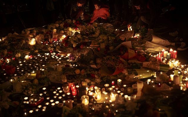 People light candles outside The Belle Equipe restaurant in Paris, Saturday, Nov. 14, 2015, a day after the attacks. (AP Photo/Daniel Ochoa de Olza)