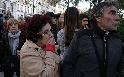 Mourners pay respects to the victims outside the Bataclan concert hall in Paris, Sunday, Nov. 15, 2015. (AP Photo/Christoph Ena)