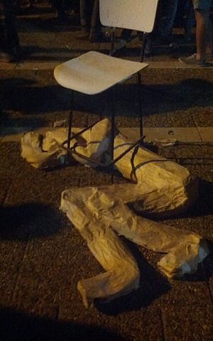 Protest art at the Rabin 20th year anniversary rally October 31, 2015, memorializing one of the Beersheba bus station attack victims, Eritrean Haftum Zarhum. Zarhum was mistaken for a terrorist, and video footage shows an angry mob of Israelis trying to attack him as he lay writhing in pain under a chair. (Melanie Lidman/Times of Israel) Protest art at the Rabin 20th year anniversary rally October 31, 2015, memorializing one of the Beersheba bus station attack victims, Eritrean Haftum Zarhum. Zarhum was mistaken for a terrorist, and video footage shows an angry mob of Israelis trying to attack him as he lay writhing in pain under a chair. (Melanie Lidman/Times of Israel)