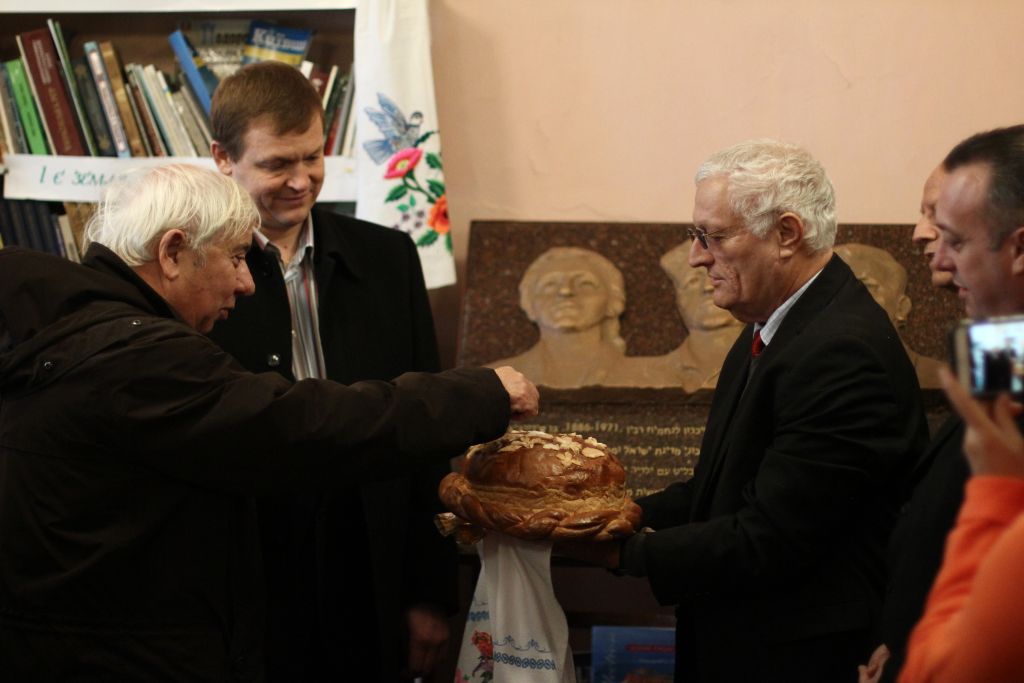 Eitan Haber, Yitzhak Rabin's chief of staff, takes a piece of a traditional Ukranian bread at a ceremony in memory of the prime minister (Courtesy Dmitriy Galin)