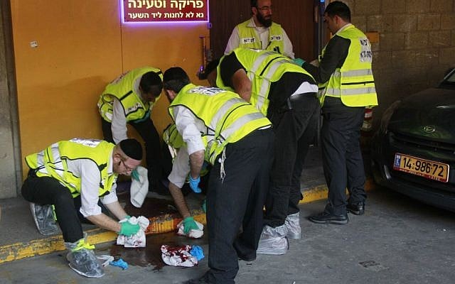 Members of the independent emergency service ZAKA cleaning blood at the scene of a stabbing attack in Tel Aviv on November 19, 2015. (Judah Ari Gross/ Times of Israel)