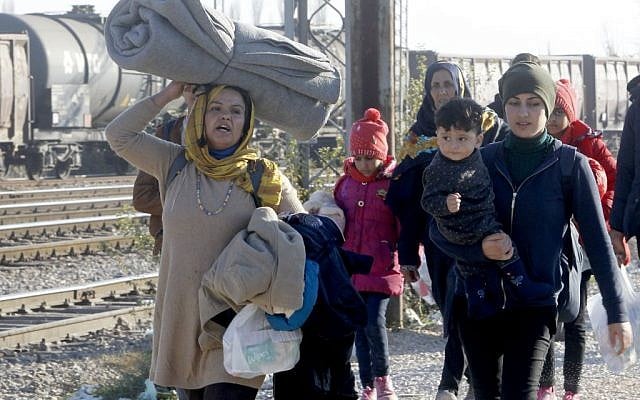 Migrants and refugees walk towards the border with Serbia, after arriving at the transit center for refugees near the village of Tabanovce, in northern Macedonia, November 19, 2015. (AP/Boris Grdanoski) Migrants and refugees walk towards the border with Serbia, after arriving at the transit center for refugees near the village of Tabanovce, in northern Macedonia, November 19, 2015. (AP/Boris Grdanoski)