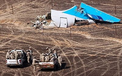 In this Sunday, Nov. 1, 2015 file photo provided by Russian Emergency Situations Ministry, Egyptian Military on cars approach a plane's tail at the wreckage of a passenger jet bound for St. Petersburg in Russia that crashed in Hassana, Egypt. (Maxim Grigoriev/Russian Ministry for Emergency Situations via AP, File)