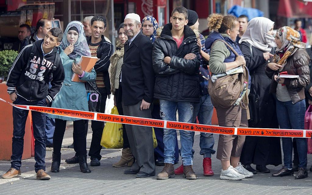 People watch behind a police line as Israeli police officers work at the site of an attempted stabbing attack outside Damascus Gate in Jerusalem's Old City, Tuesday, Nov. 10, 2015. (AP/Ariel Schalit)