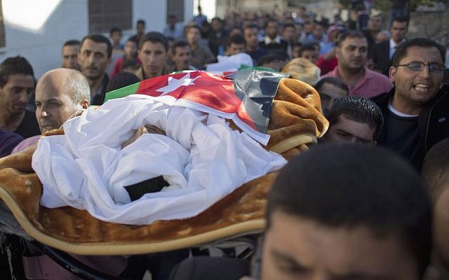 Mourners carry the body of Jordanian police Cpt. Anwar Abu Zaid, 28 wrapped with a Jordanian flag, during his funeral at his home village of Rimoun, near the city of Jerash, Jordan, Thursday, Nov. 12, 2015. The police captain opened fire Monday on instructors at an international police training center in Jordan's capital, killing at least five people, including two Americans, before being shot dead by security forces. (AP/Nasser Nasser)