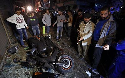 People gather near the site of a twin suicide attack in Burj al-Barajneh, southern Beirut, Lebanon, Thursday, Nov. 12, 2015 that struck a Shiite suburb killed and wounded dozens, according to a Lebanese official. (AP Photo/Bilal Hussein) 