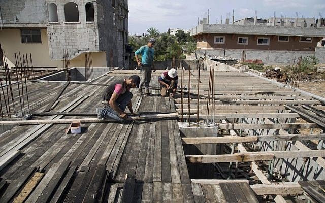 In this Wednesday, Oct. 28, 2015 photo, Palestinians work on rebuilding a house which was destroyed during the last summer's war between Israel and Hamas, Gaza City. (AP Photo/Adel Hana)