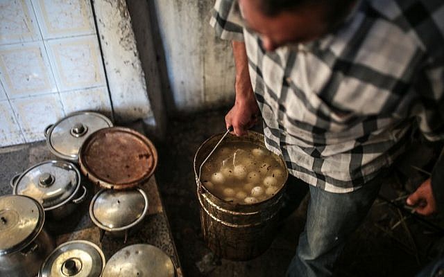 A man prepares meals for his family on the eve of Shabbath, at Hara Kbira, the main Jewish neighborhood on the Island of Djerba, southern Tunisia, October 29, 2015. (Photo by AP Photo/Mosa'ab Elshamy)