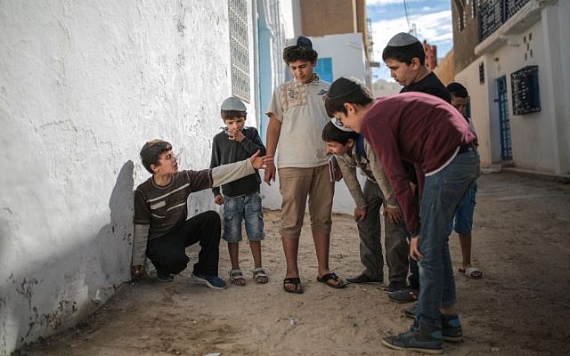 Boys play with marbles outside their school at Hara Kbira, the main Jewish neighborhood in the Island of Djerba, southern Tunisia, October 29, 2015. (Photo by AP Photo/Mosa'ab Elshamy)