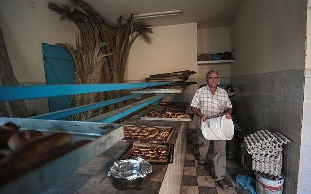 Yofel Sabbagh, 46, walks inside a bakery as he prepares Challah, a special Jewish bread, on the eve of Shabbath, at Hara Kbira, the main Jewish neighborhood on the Island of Djerba, southern Tunisia, October 29, 2015. (Photo by AP Photo/Mosa'ab Elshamy)