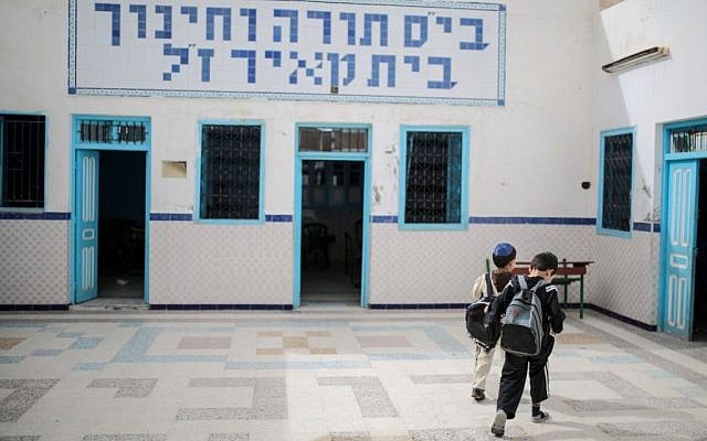 Boys walk inside a Talmudic school at Hara Kbira, the main Jewish neighborhood on the Island of Djerba, southern Tunisia, October 29, 2015. When school lets out, the streets around the ancient synagogue on this Tunisian island fill with rambunctious boys wearing Jewish kippahs and girls in long skirts, shouting to each other in Hebrew, Arabic and French.  (Photo by AP Photo/Mosa'ab Elshamy)