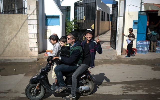 A boy gestures to the camera as he and his relatives leave school at Hara Kbira, the main Jewish neighborhood on the Island of Djerba, southern Tunisia, October 29, 2015. (Photo by AP Photo/Mosa'ab Elshamy)