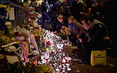 People place flowers and candles on the pavement near the scene of the November 13, 2015 Bataclan Theater terrorist attack, on November 14, 2015 in Paris, France. (Photo by Jeff J Mitchell/Getty Images/JTA)