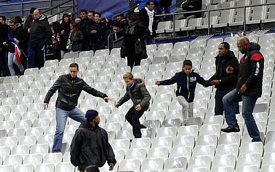 Spectators invade the pitch of the Stade de France stadium after the international friendly soccer France against Germany, Friday, November 13, 2015 in Saint Denis, outside Paris. During the first half of France's soccer match against Germany on Friday, two explosions went off nearby. (Photo by AP Photo/Michel Euler)
