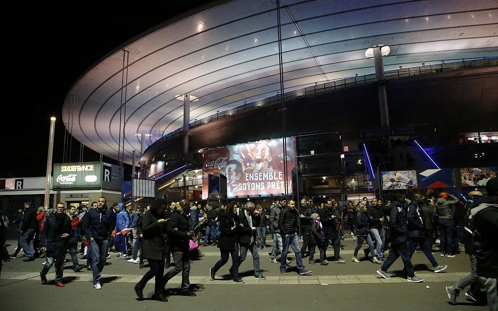 Fans leave the Stade de France amid a stream of fatal attacks in Paris, including explosions near the stadium, November 13, 2015. (Foto AP/Michel Euler)